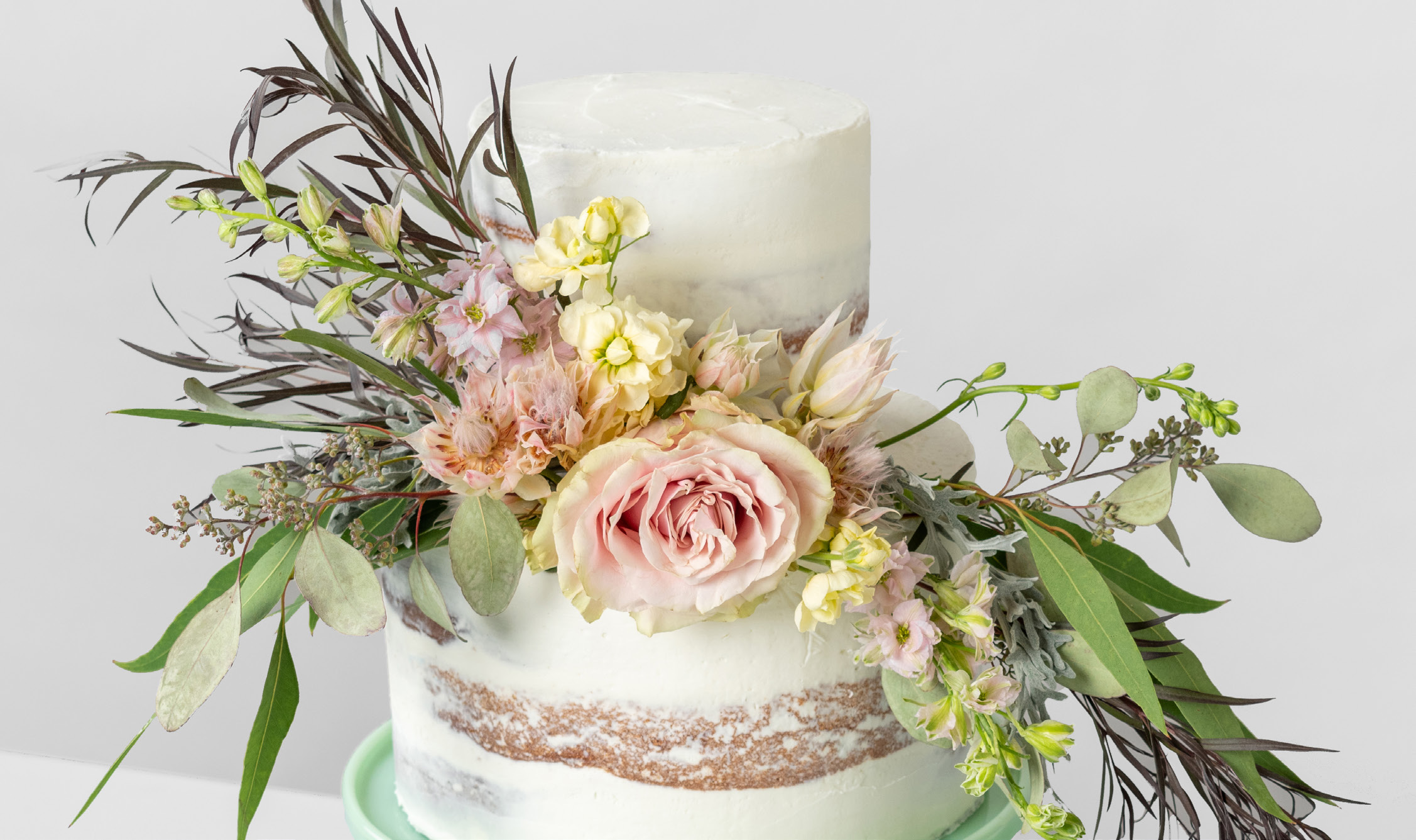 Cake decorated with fresh flowers and greenery