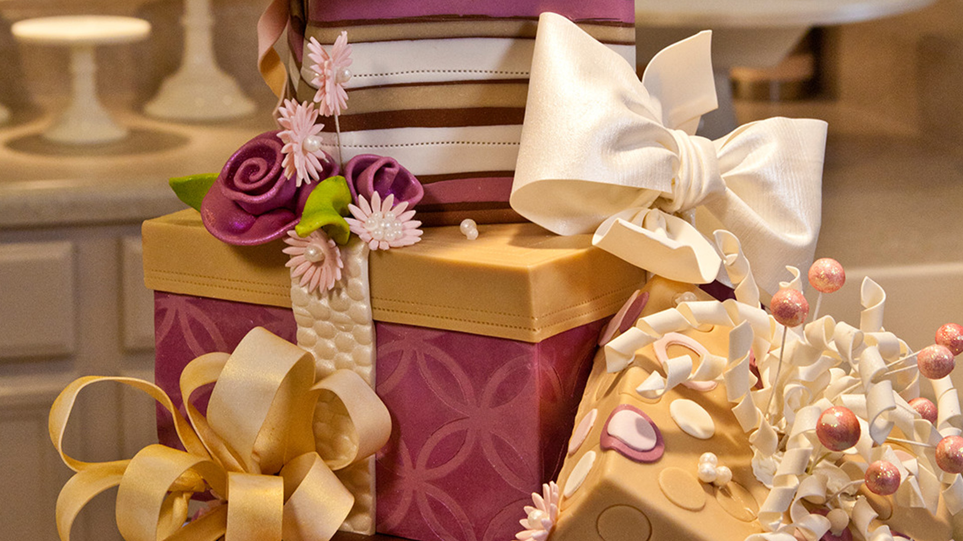 Maroon and gold cake with bows and flowers